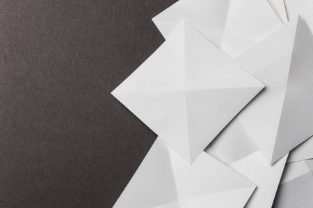 White cards folded in pyramidal shapes; isolated on grey backgroundの写真素材