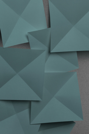 Overlapping geometric shapes of paper, isolated on grey backgroundの写真素材