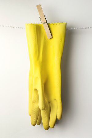 Yellow rubber gloves hanging with a clothespinの写真素材