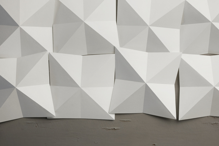 Geometric shapes of white paper folded, old wooden board on backgroundの写真素材