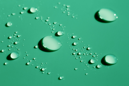 Green water drops on smooth surfaceの写真素材