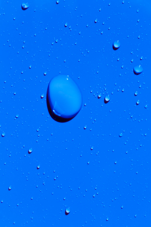 Drops of water on a blue color surface, abstract backgroundの写真素材