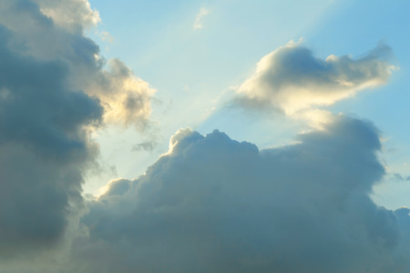 Sunbeams in the clouds at sunset, blue sky backgroundの写真素材