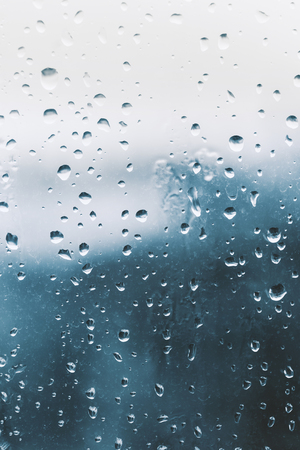 Raindrops on the window glass, blue backgroundの写真素材