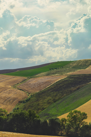 Countryside landscape, cultivated fields and cloudy skyの写真素材