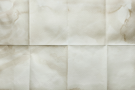 Empty sheet folded in eight, old paper with stained edgesの写真素材