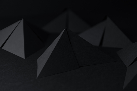Black triangular shapes of paper on dark backgroundの写真素材