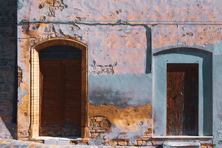 Old building, facade of abandoned house, cracked plaster and exposed brickの写真素材