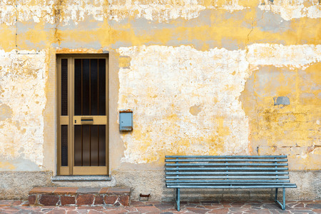 Exterior old building, cracked plaster of the facade with front door and mailboxの写真素材