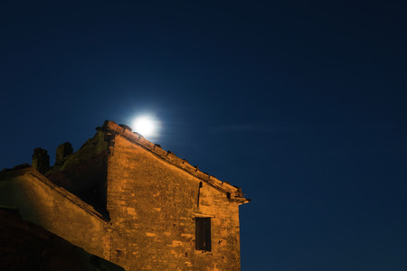 Moon rises behind an ancient ruined building, night viewの写真素材