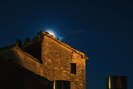 Moon rises behind an ancient ruined building, night viewの写真素材
