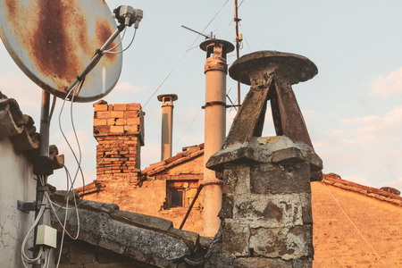Old brick chimneys and battered antennas, view from the roofsの写真素材
