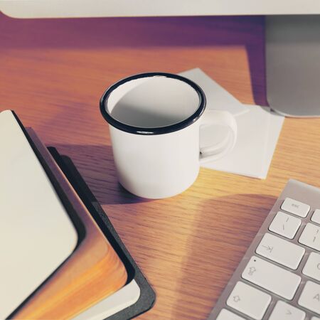 Office desk table with supplies. Cup, note book open and keyboard