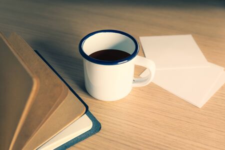 Office desk table with note book open and coffee cupの写真素材