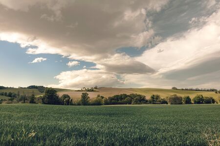 View of rural landscape, farmland and dramatic sky in springの写真素材