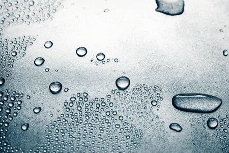 Water drops on rough silvery background, close-upの写真素材