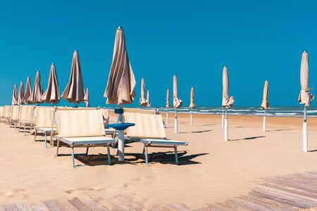 Beach in late summer, deck chairs and parasols, blue skyの写真素材