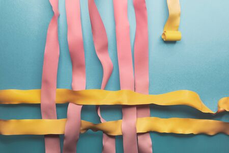 Close-up of pink and yellow ribbons on blue backgroundの写真素材
