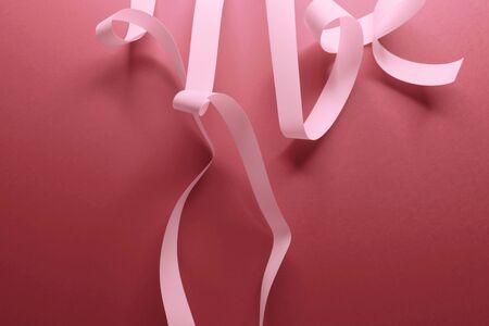 Close-up of pink ribbons on red backgroundの写真素材