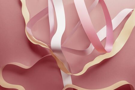 Close-up of pink ribbons on red backgroundの写真素材