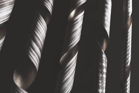 Twisted paper decorative elements on black background, abstract の写真素材