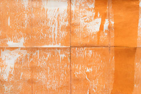 Old orange paper folded and stained, texture backgroundの写真素材