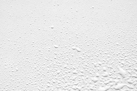 Close up of water drops on smooth surface, white backgroundの写真素材