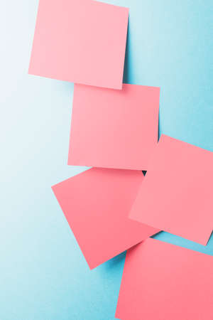 Close-up of blank notes paper isolated on blue, texture backgroundの写真素材