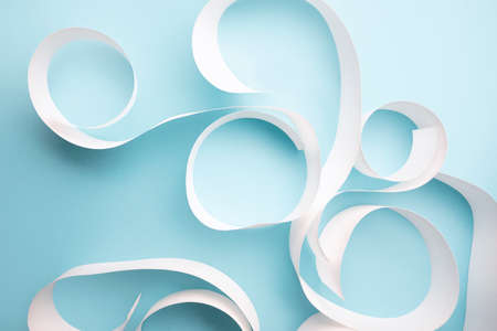 Close-up of white paper curls on light blue backgroundの写真素材