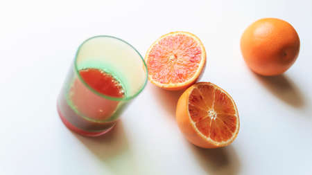 Glass of orange juice and fruits, white backgroundの写真素材