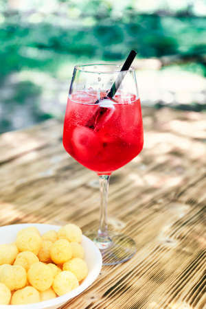 Refreshing aperitif, close-up of red drink with iceの写真素材