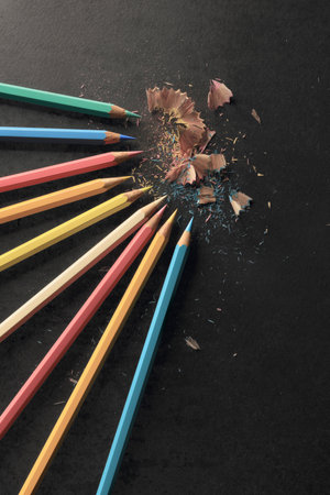 Sharpening colored pencils, black paper background