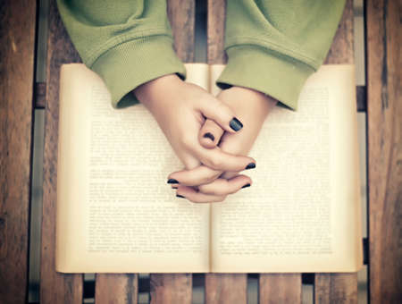 A teenager sitting at the table with an open bookの写真素材