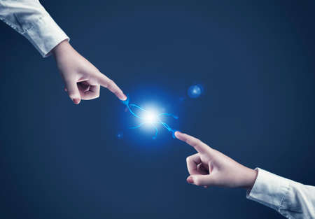 Two hands reaching towards each and make a connectionの写真素材