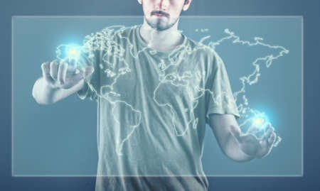 Young man standing and working wth touch screen technology, world mapの写真素材