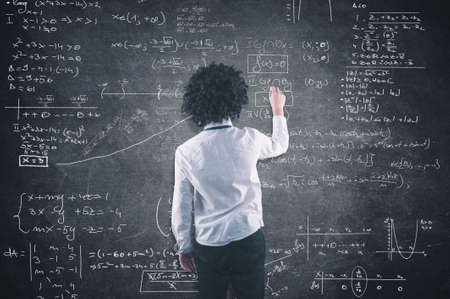 Teenager solving a math equation on blackboardの写真素材