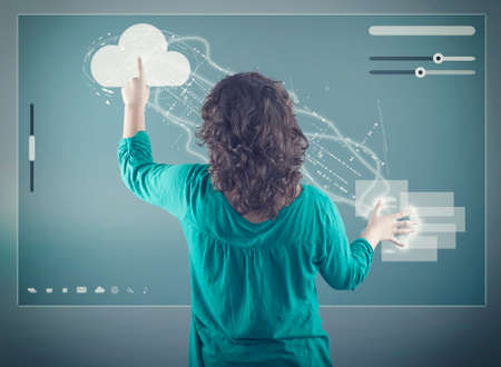 The young girl transfering data froma cloud to folders on a modern screenの写真素材