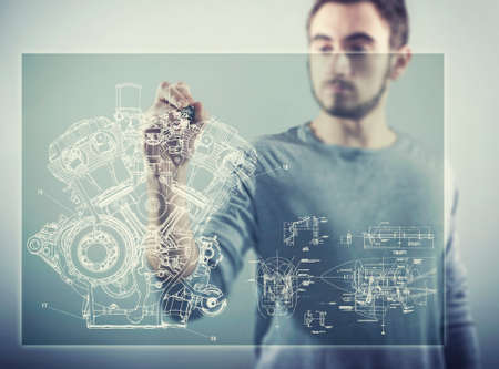 The young man works with huge touch screen, draw a sketch mechanics