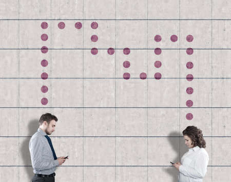 Teenagers communicating on phone next to a wall painted with dots ,modern technology concept.