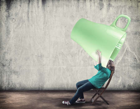 Young girl drink from a huge cup of coffeeの写真素材