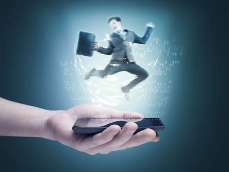 Holding a phone with hologram of a businessman jumpingの写真素材