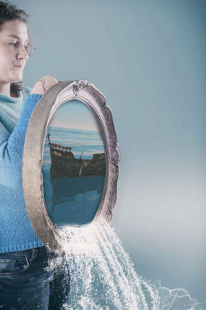 Young girl holding a painting of an ocean  that flows in waterfall. 3d waterfallの写真素材