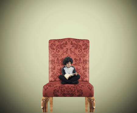 Teenager reading a book on a huge chair