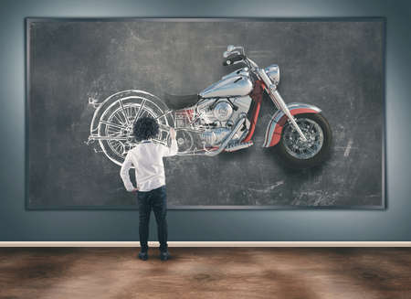 Young man draw a motorcycle on blackboard and half of it becomes real.