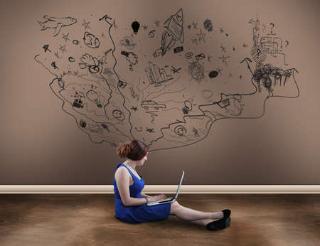 Teenager girl with a laptop next to a painted wall suggesting imagination, chaotic and creative...