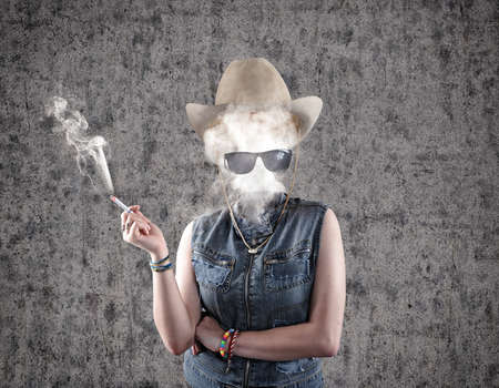 Girl smoking cigarette and the smoke rises up in place of head.の写真素材