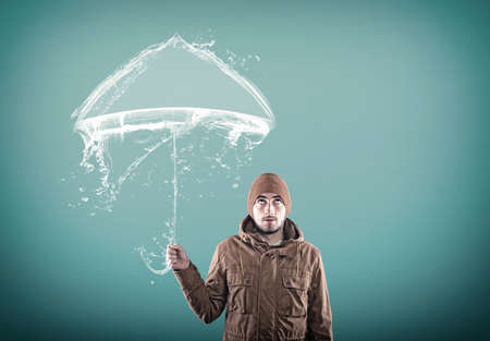 Young man using an umbrella made of water.の写真素材