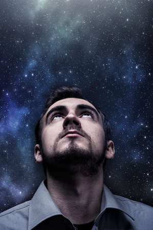 Young man looking up to the night skyの写真素材