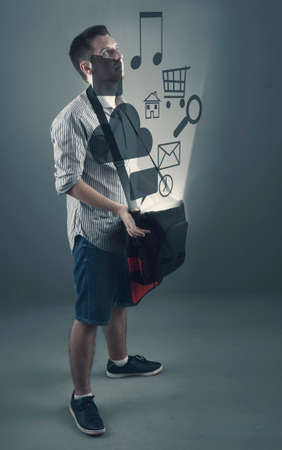 Man holding his backpack and it icons rising from itの写真素材