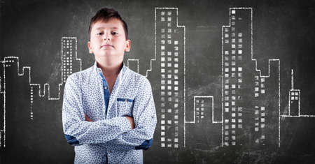 Kid stading in front of a urban city building on chalk blackboardの写真素材